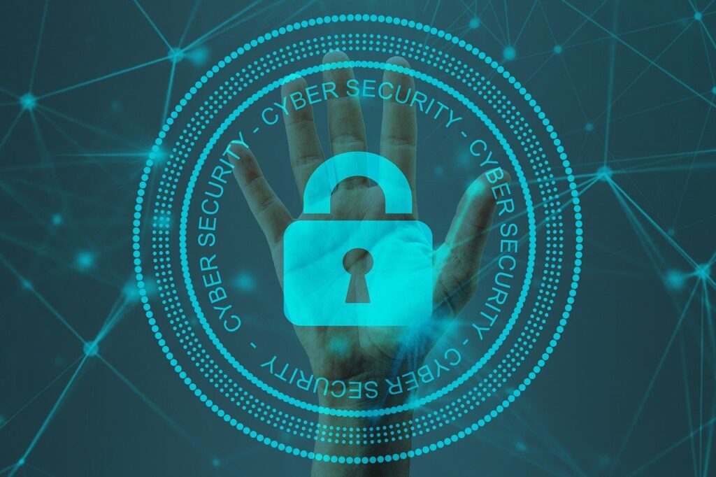 A Cybersecurity image showing a hand and a lock preventing access with the words Cyber Security in a circle around the hand.