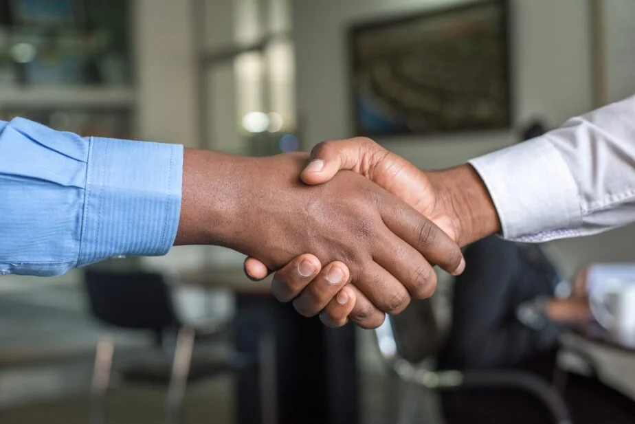 A Picture Of A Man Shaking Another Man'S Hand At A Job Interview. Learn What Questions To Ask At The End Of An Interview.
