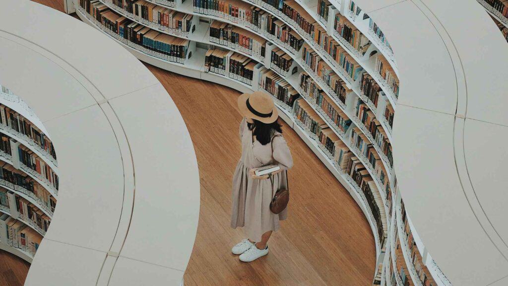 A picture of a woman in a library, representing the publishing and distribution of books.