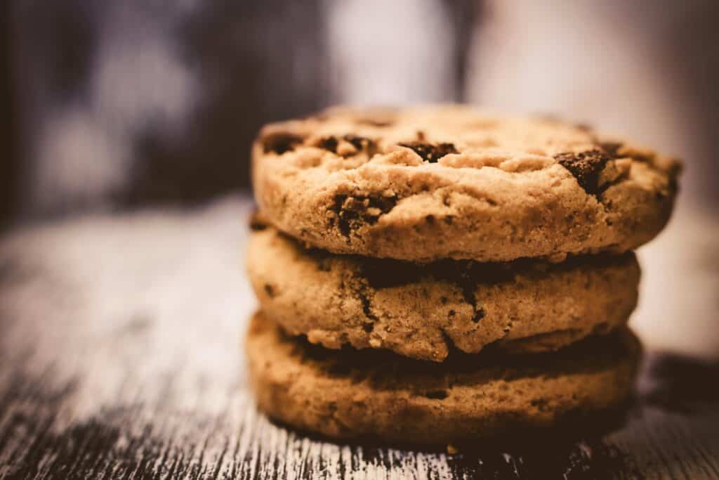 An image of three chocolate chip cookies stacked.  This image represents our Cookie Policy.